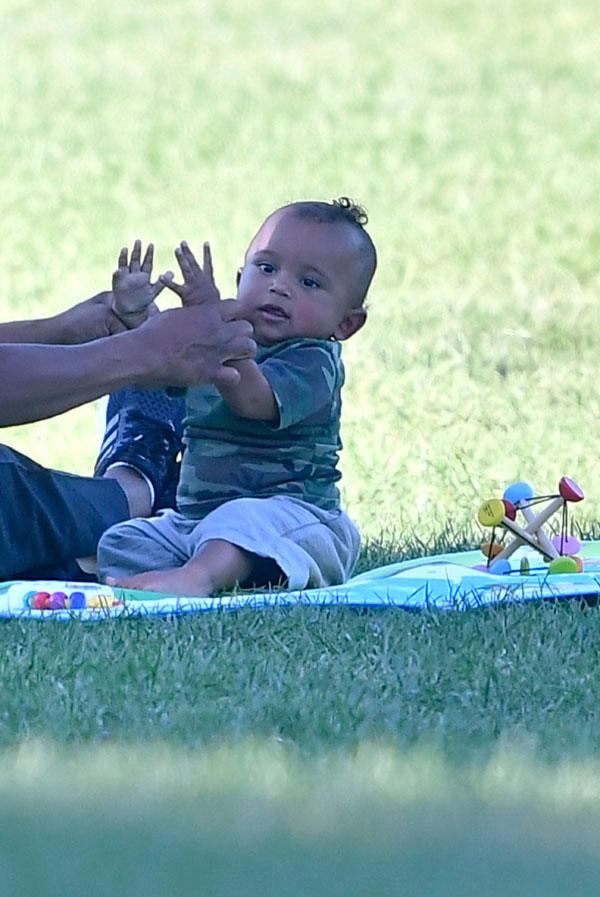 saint west smelling shoe laughing having fun in the park