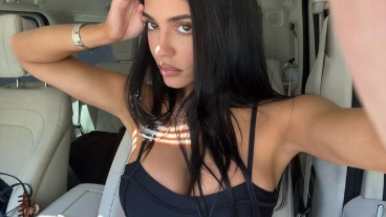 Image of Kylie Jenner wore a matching black sports bra and leggings for the photos. 