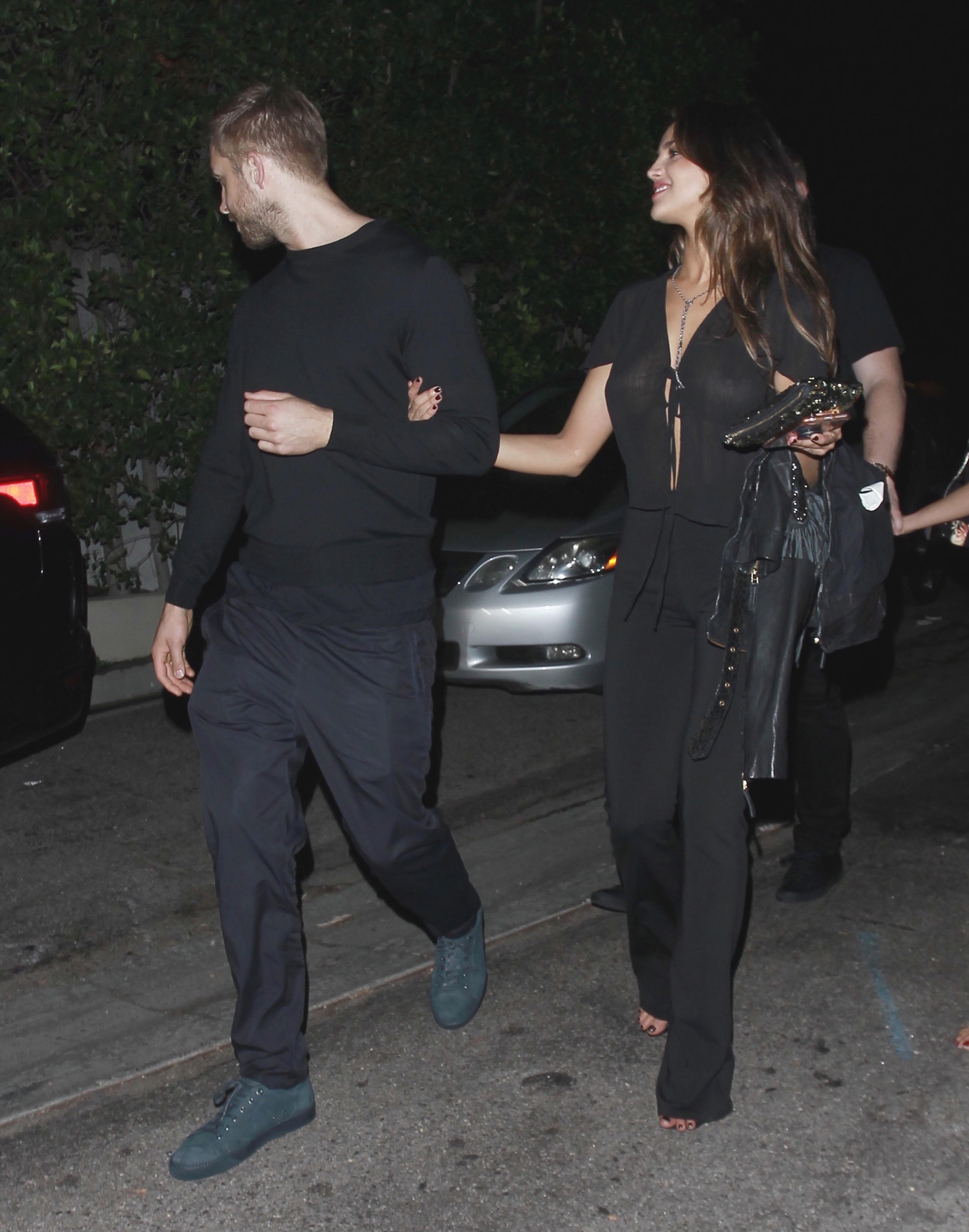 EXCLUSIVE: **PREMIUM EXCLUSIVE RATES APPLY** Calvin Harris is spotted in an arm in arm embrace with Eiza Gonzalez while leaving a party on Los Angeles.