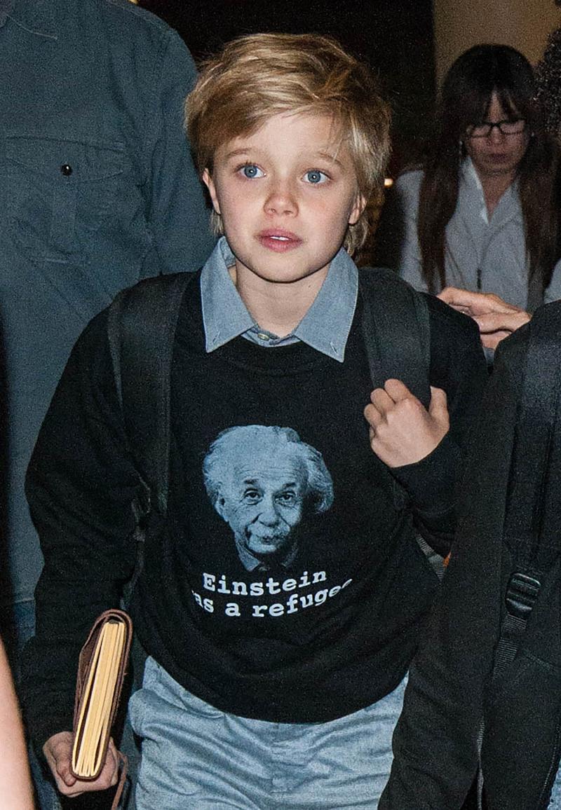 Shiloh Jolie Pitt fashion statement &#8220;Einstein was a refugee&#8221; t shirt with mom Angelina Jolie and siblings, Pax, and Zahara, at LAX airport