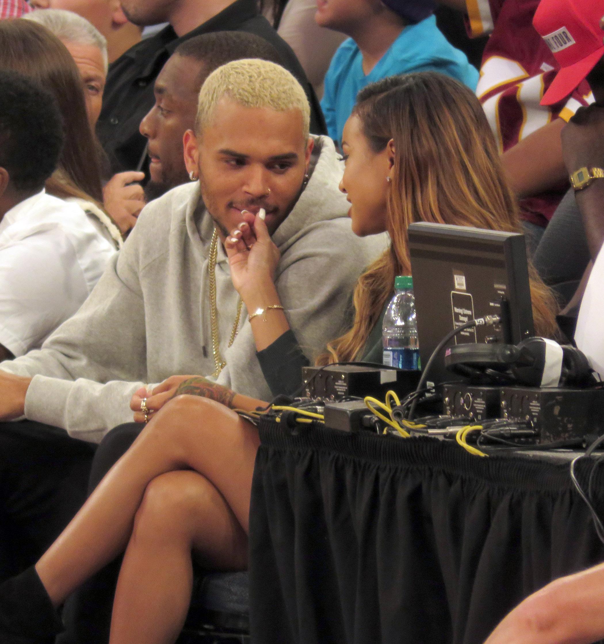 Chris Brown takes out his golden mouth grill and then stuffs in inside his girlfriend&#8217;s purse at basketball game in NYC