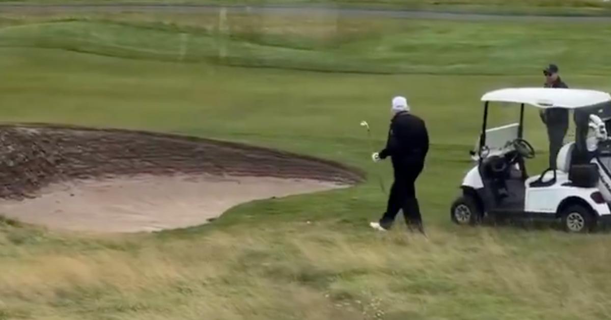 Image of one of Donald Trump's caddies could be seen tossing the golf ball on the grass in front of a bunker.