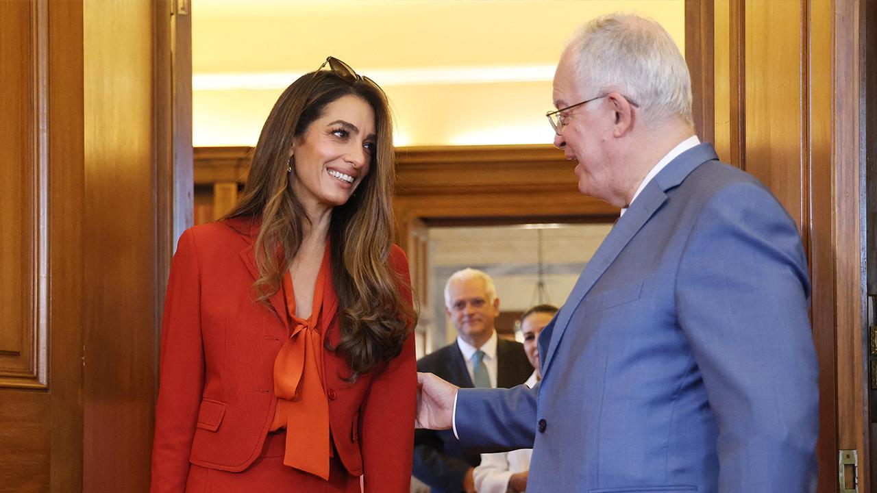 Image of The human rights lawyer turned heads in a bold red ensemble as she met with the Greek president.