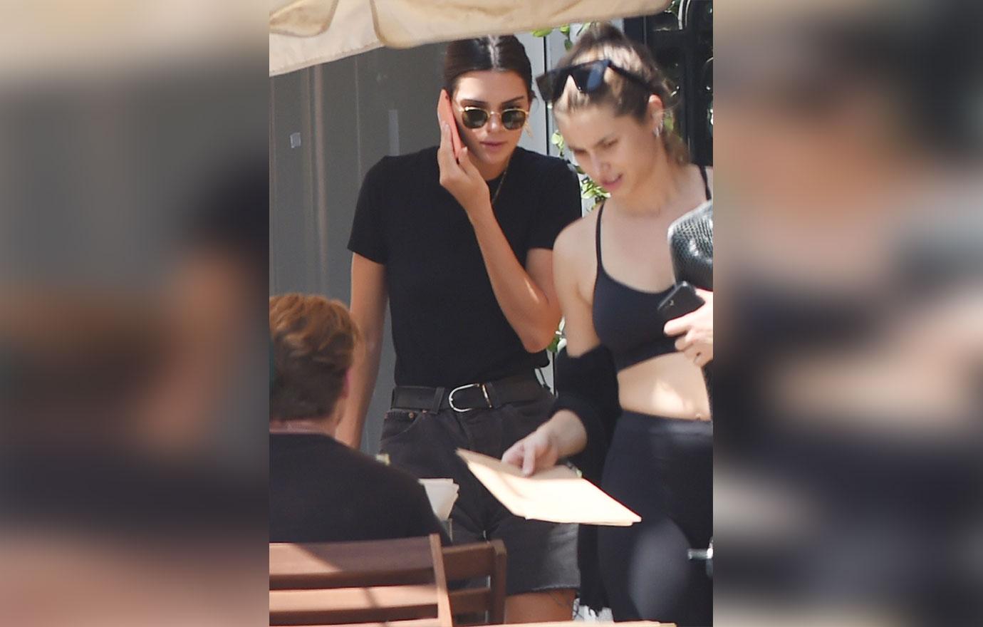 Kendall Jenner wears cut off jean shorts and a red hand purse to lunch in West Hollywood