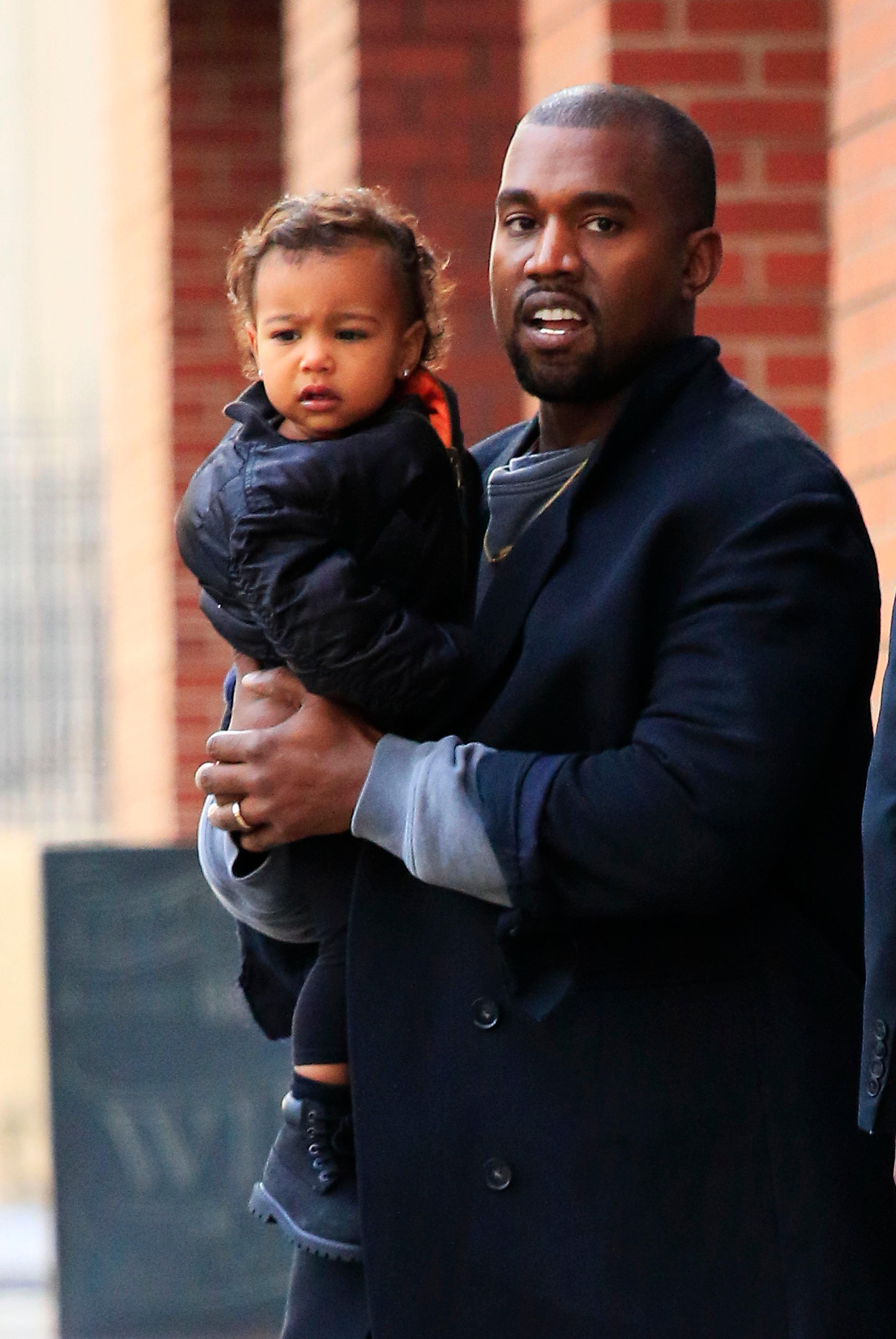 EXCLUSIVE: Kanye West carries baby daughter North West in SoHo, New York City