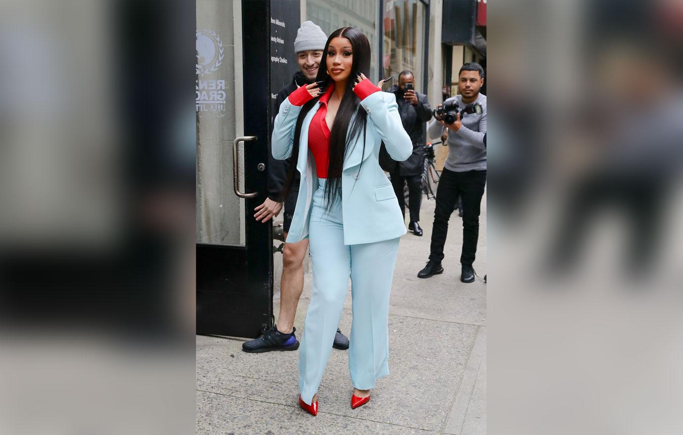 Cardi B dons a baby blue suit with a red shirt and pumps as she