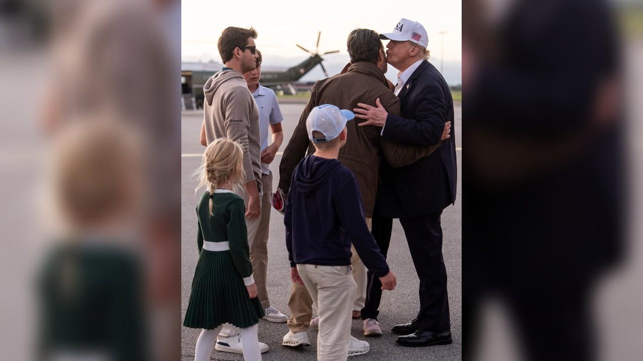 Image of Donald Trump pulled son Donald Trump Jr. in for an affectionate farewell as several of his grandchildren stood nearby.