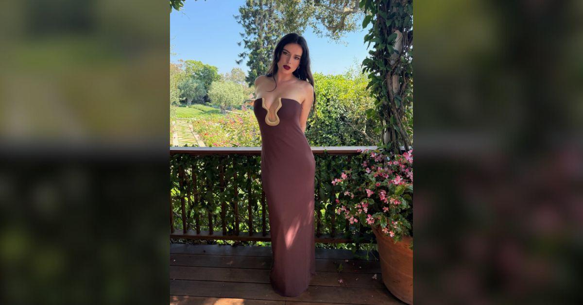 Photo of Bella Thorne posed in front of a beautiful garden setting.