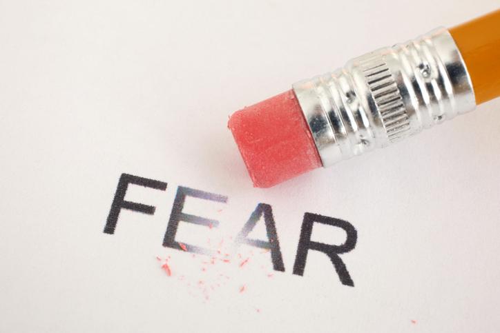 A pencil erasing the word fear