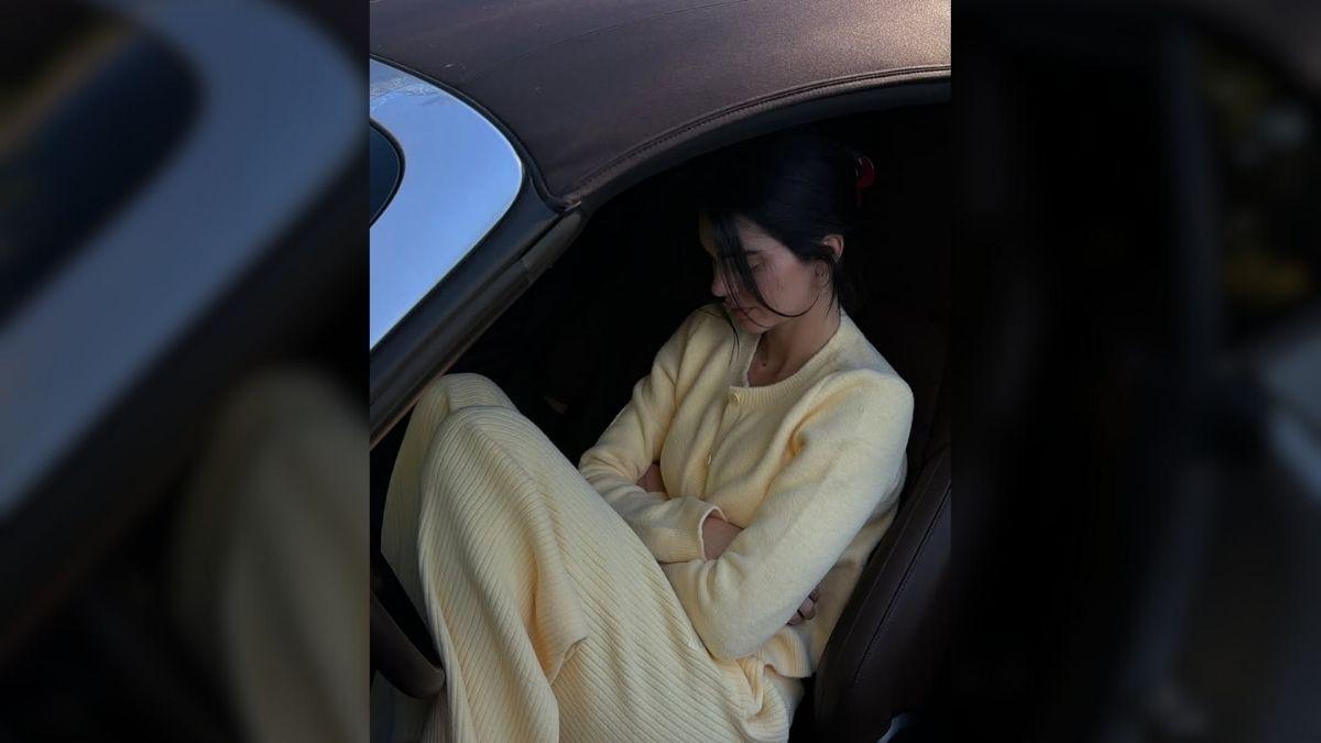 Image of Accessories like a black bag, flats, red clip, and sunglasses completed her look.