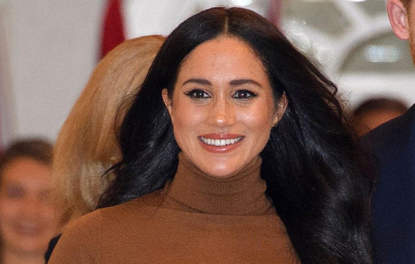 Meghan Markle smiled broadly as she went out in a brown turtleneck sweater.