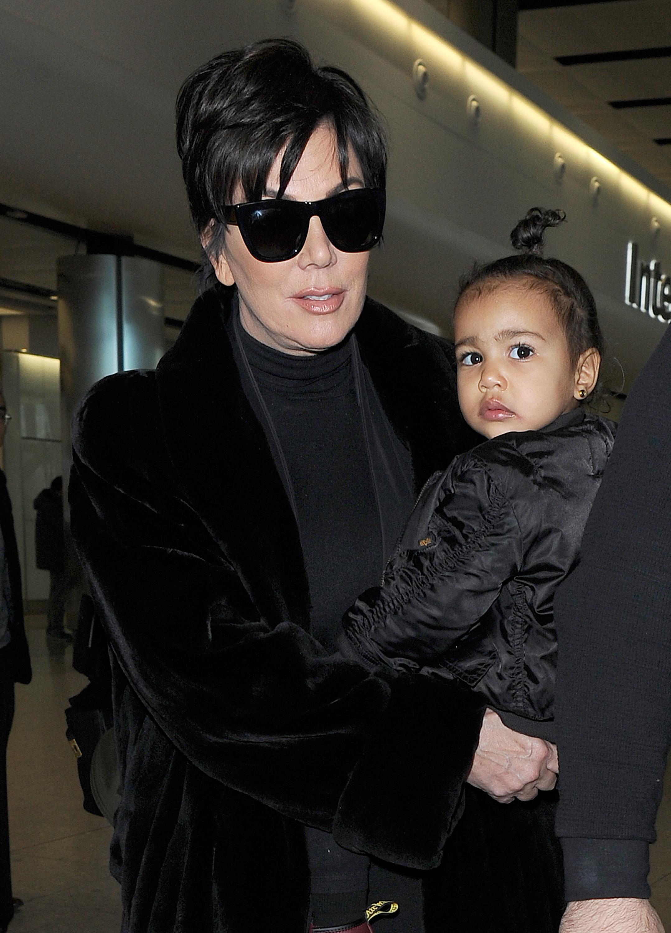 Kris Jenner arrives at Heathrow Airport, carrying baby North West, who was wearing a &#8220;Yeezus&#8221; bomber jacket to support her father Kanye