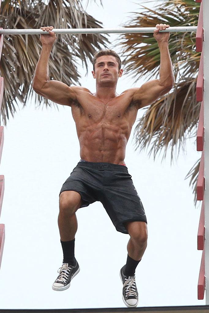 Zac Efron displaying his muscles doing pull ups in Miami Beach