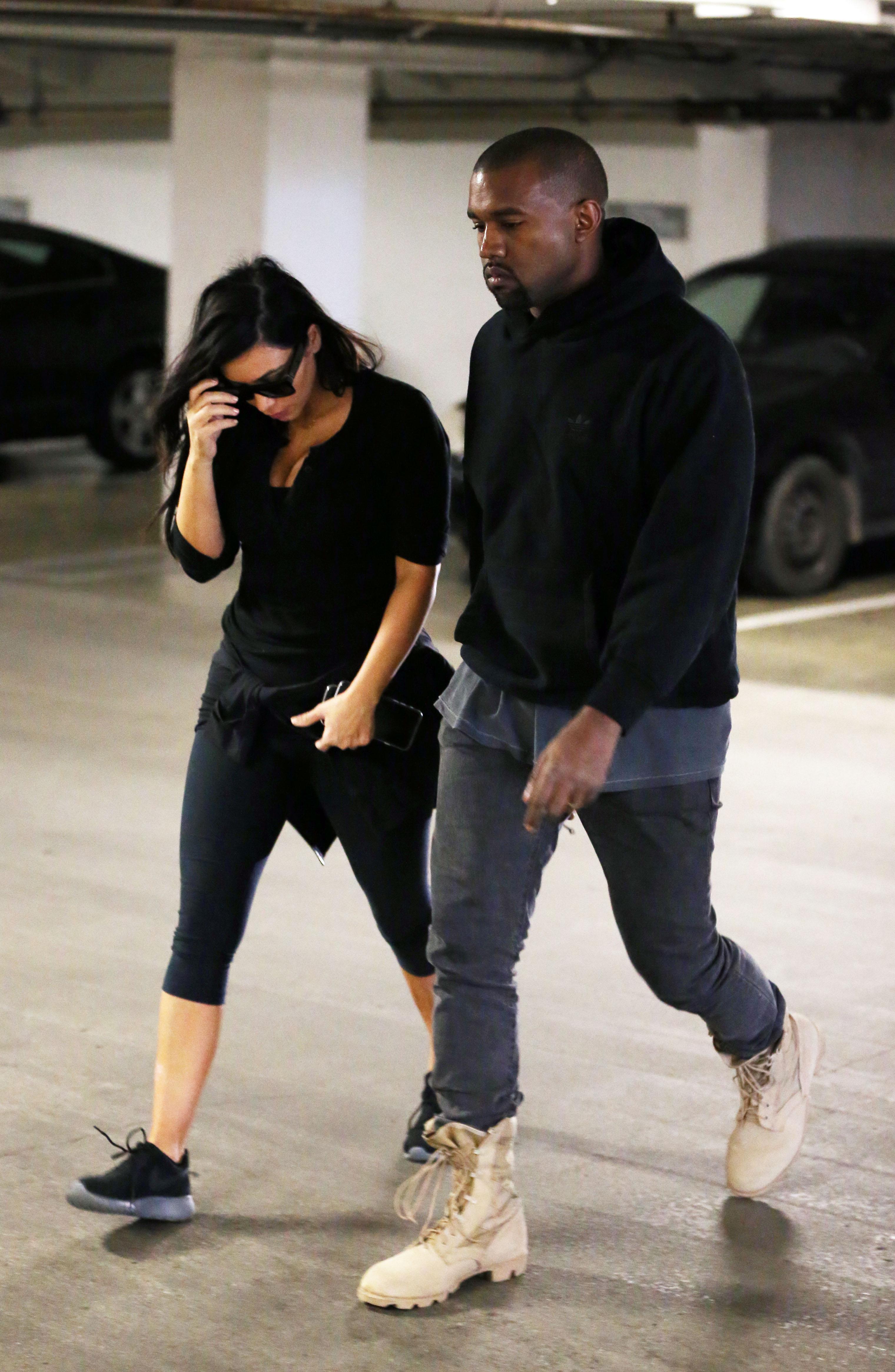 Kim Kardashian and Kanye West walking into a medical building together not looking very happy