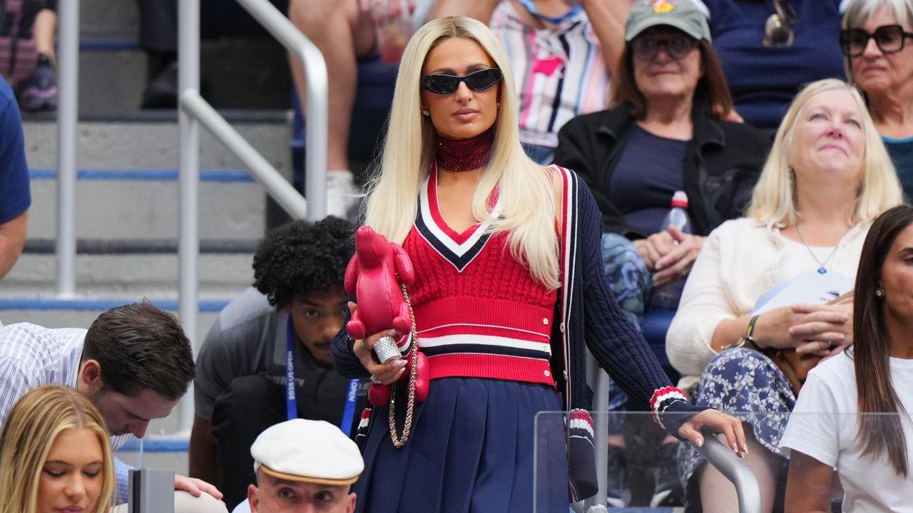 Image of Paris Hilton embraced tenniscore in a red, white and navy ensemble while watching the women's final.