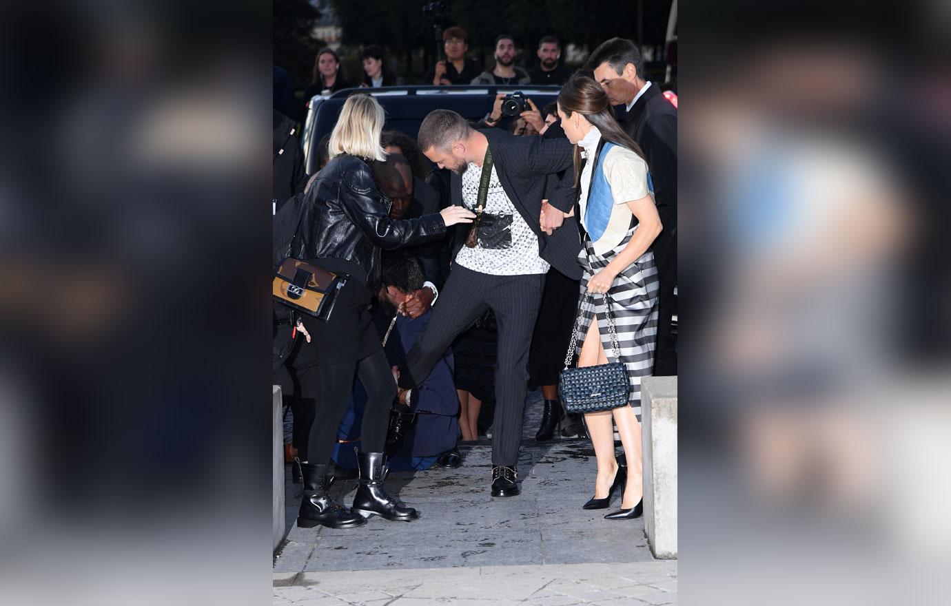 Justin Timberlake is TACKLED by a man who grabs his leg after he arrived to Louis  Vuitton show