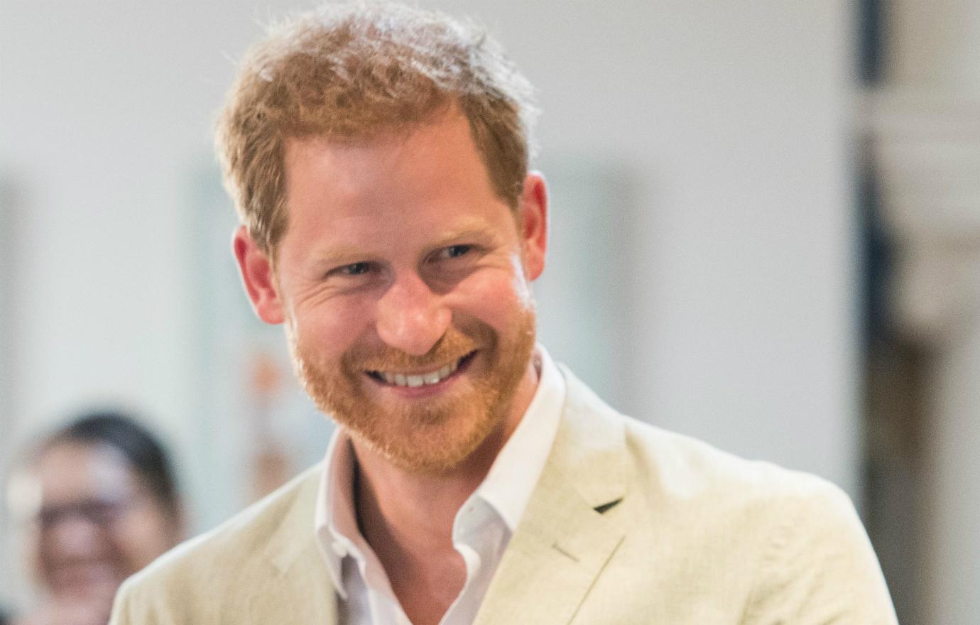 Prince Harry sported a light beige suit with a white dress shirt and no tie on his visit to Africa.