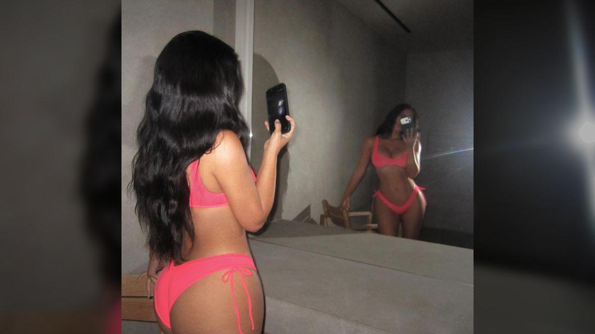 Photo of Kim Kardashian changed into a highlighter pink bikini in a sultry second look. 