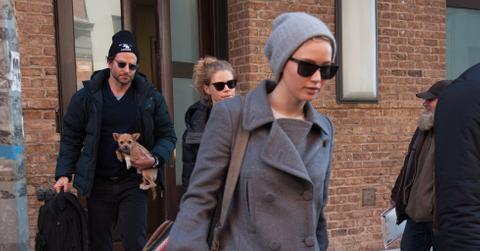 Jennifer Lawrence checks out of her hotel as Bradley Cooper holds her dog in New York City