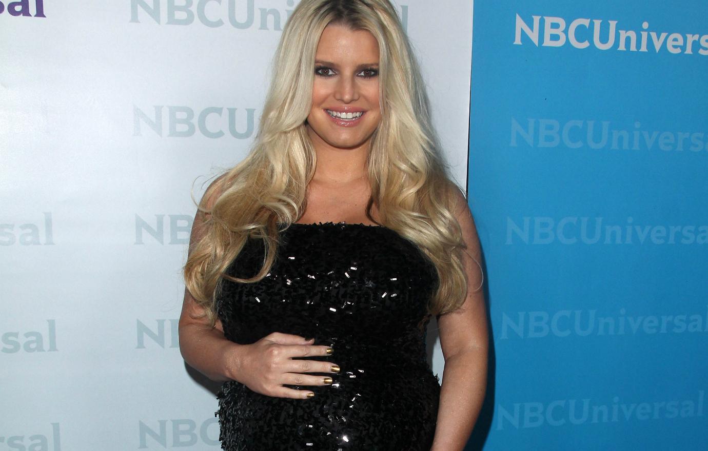 Jessica Simpson dazzled in a black shinny dress that showed off her budding baby bump.