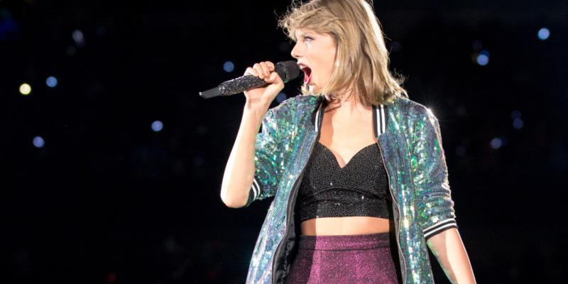 Taylor swift onstage with a bare midriff