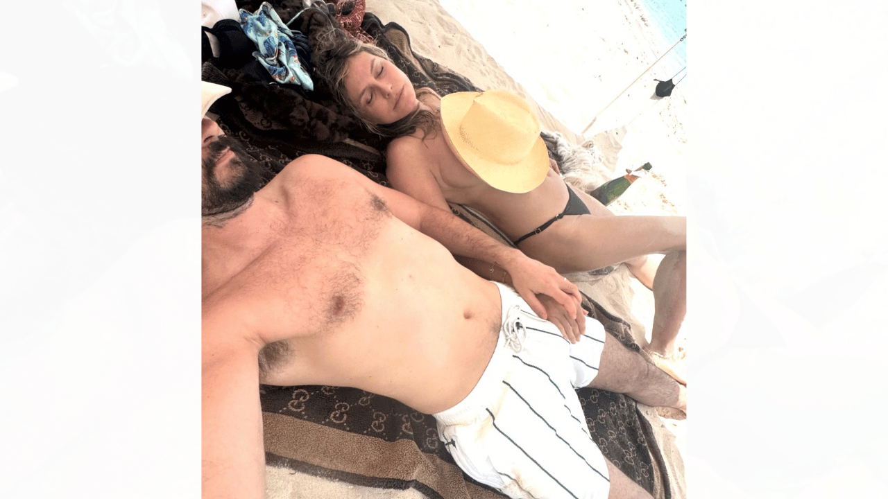 Image of Heidi Klum and Tom Kaulitz held hands for multiple photos. 