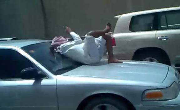 //saudi_man_texting_car_hood_freeway_stack_