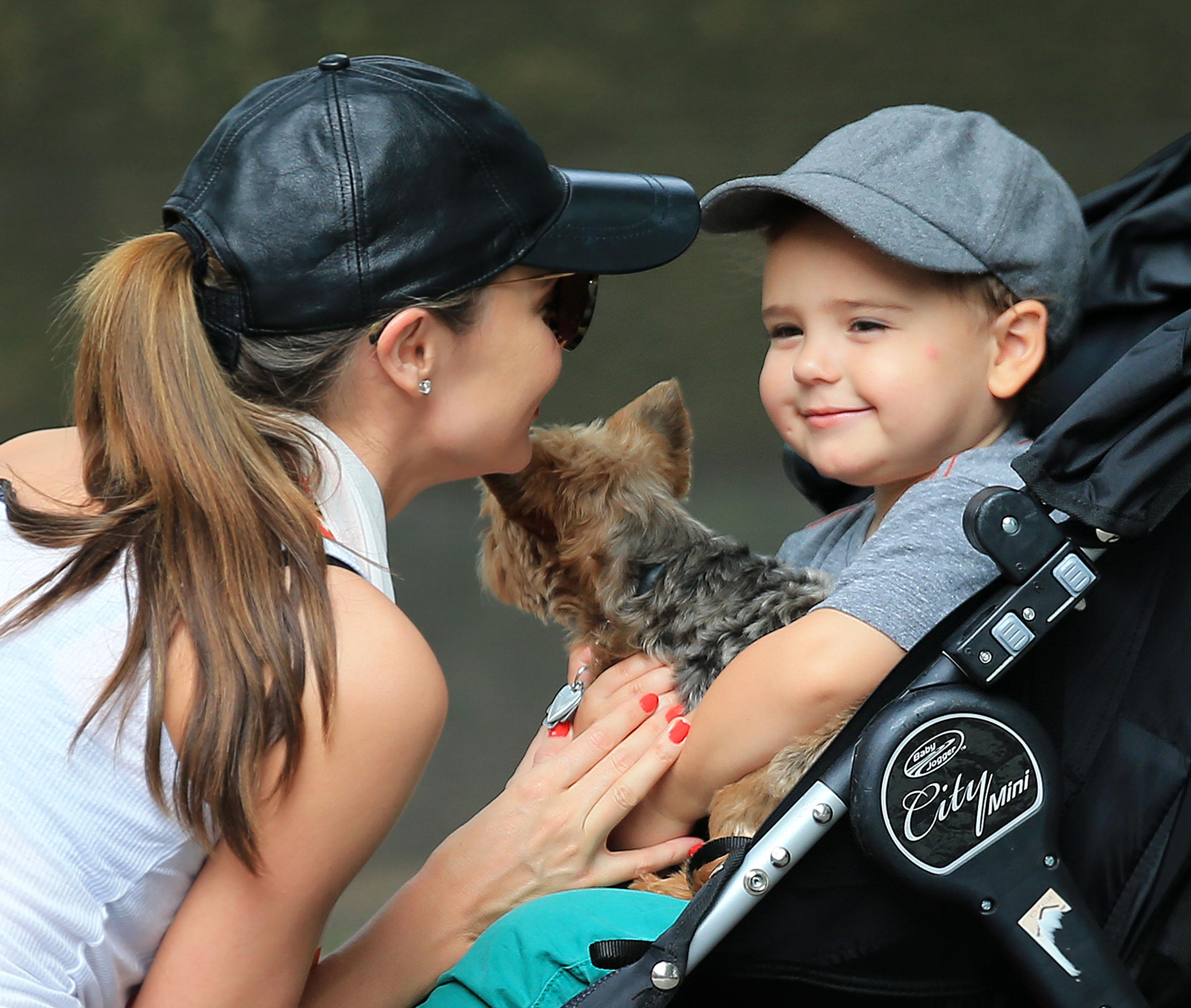 Flynn Bloom hugs and kisses his puppy Frankie while mom Miranda Kerr looks on tenderly in Central Park, NY