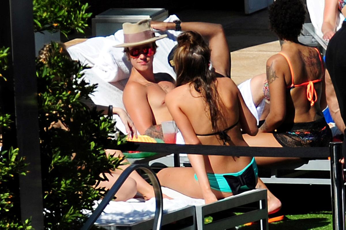 A heavily tattooed Justin Bieber kicks up his feet and relaxes poolside in Miami **USA ONLY**