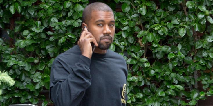 Kanye West throws up peace sign happily leaving New York City apartment.