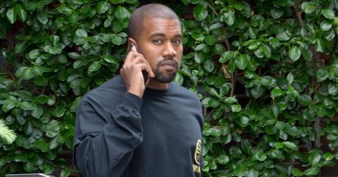 Kanye West throws up peace sign happily leaving New York City apartment.