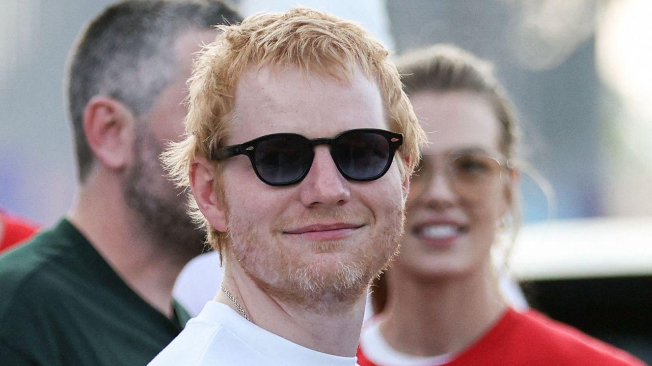 Image of Ed Sheeran’s concert protestors displayed a large banner reading 'Amerika is the heart of the snake' near the entrance.