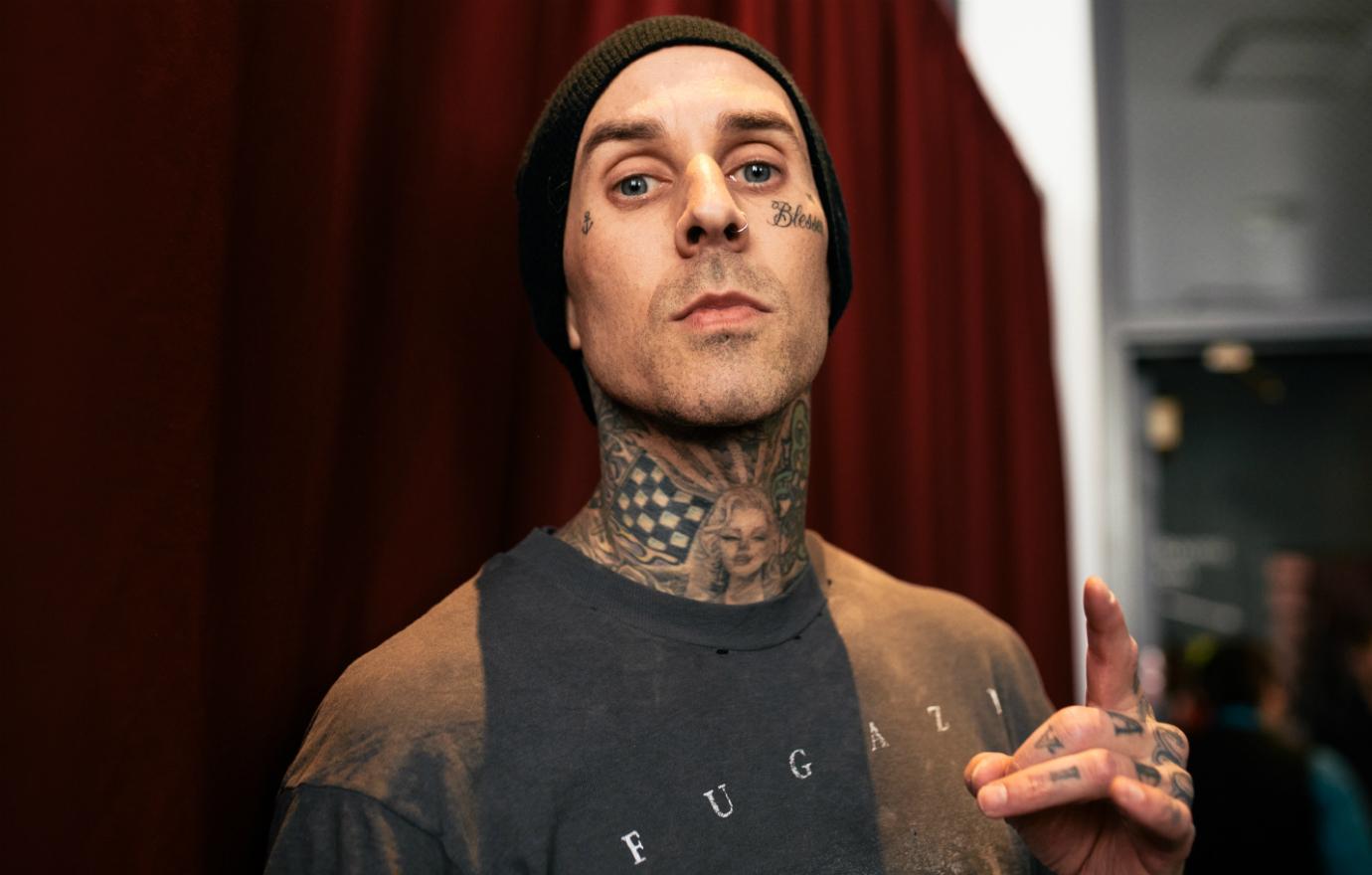 Blink 182 drummer Travis Barker was seen at the iHeartRadio Music Awards in Los Angeles, California sporting a Fugazi concert T-Shirt backstage.