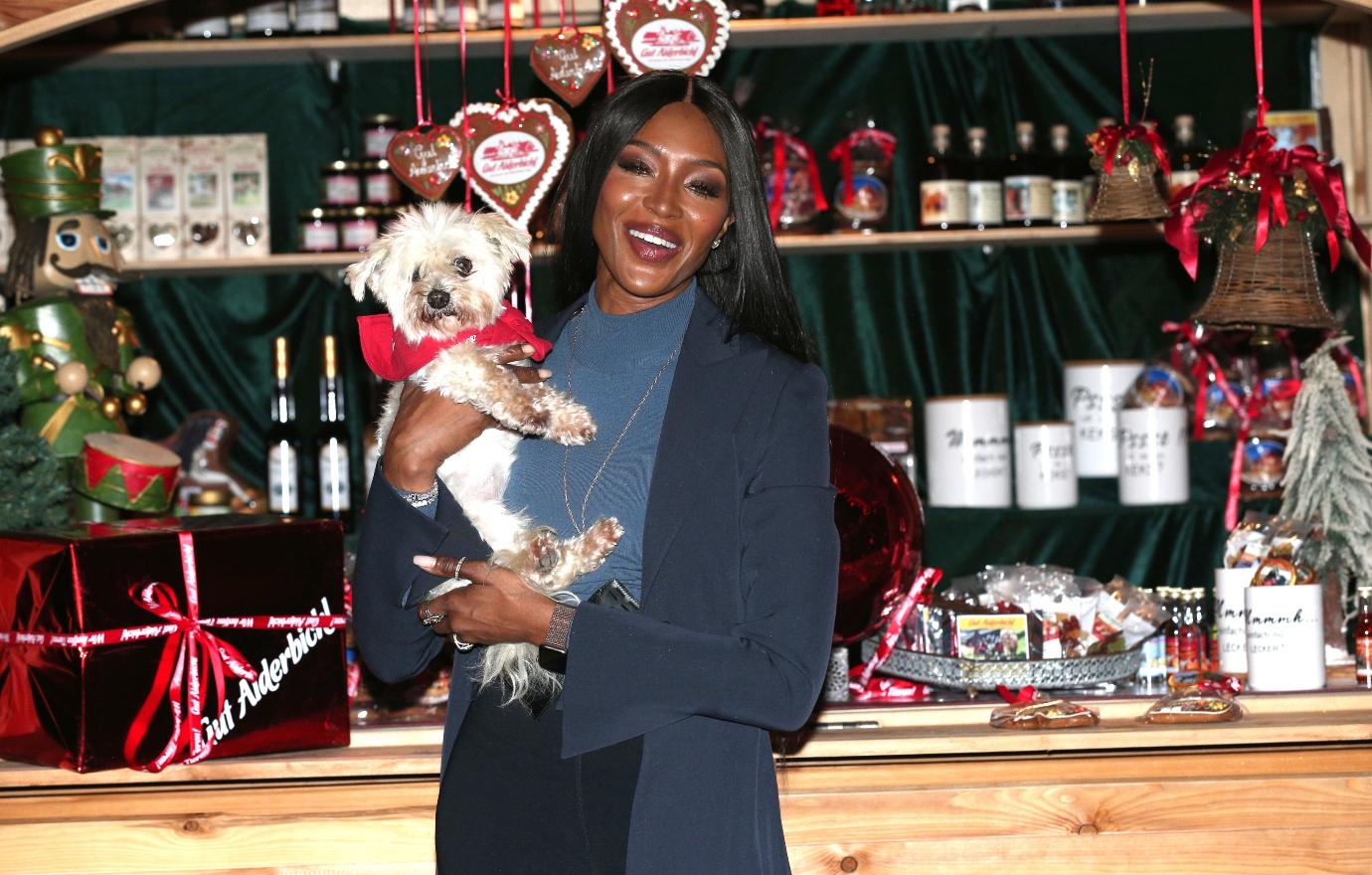 Naomi Campbell holding a white puppy at a charity event