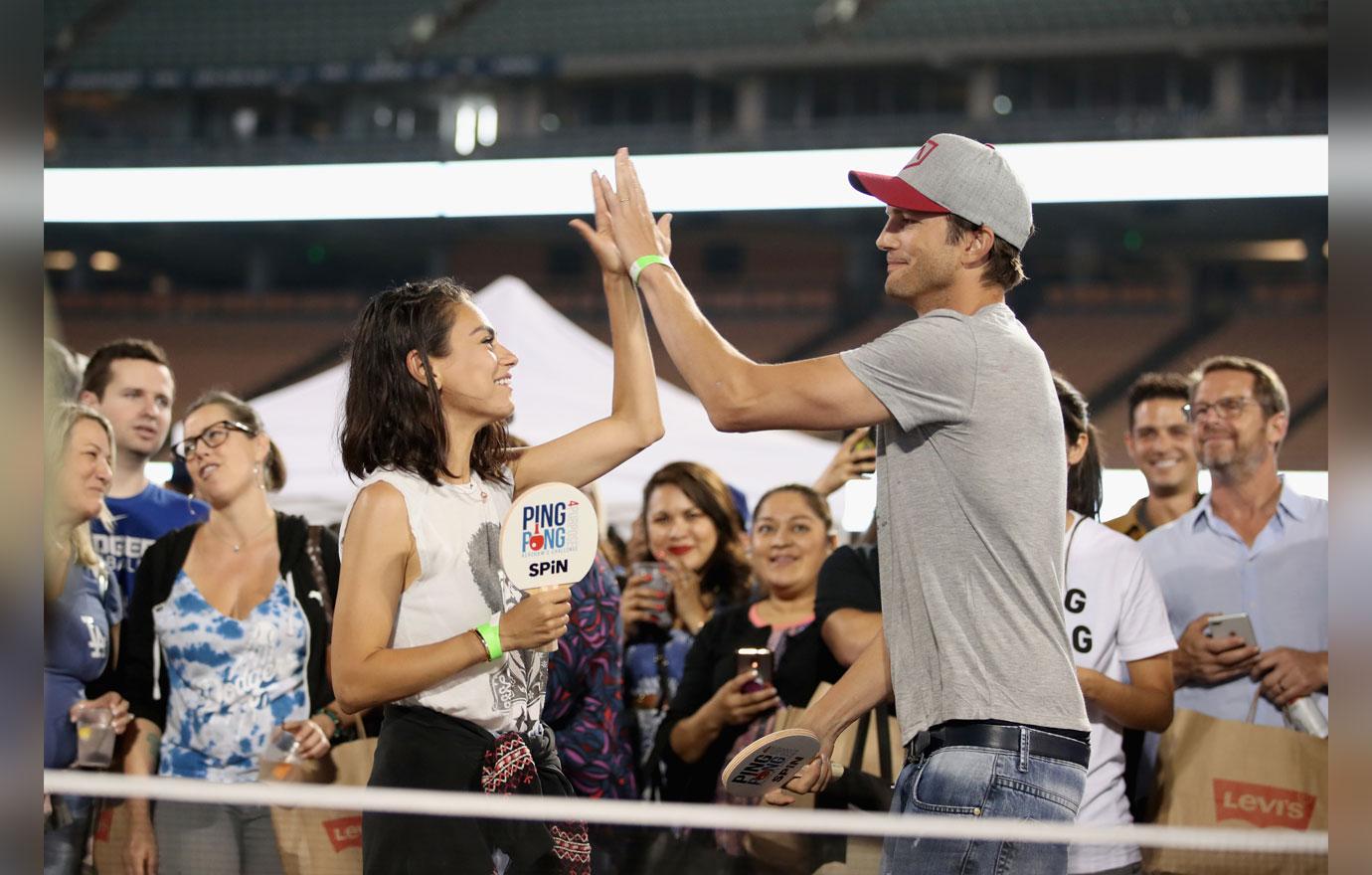 Mila Kunis and Ashton Kutcher high five.