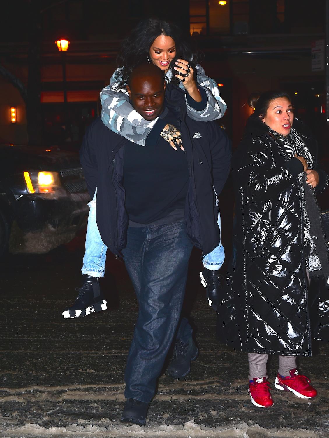 EXCLUSIVE: Rihanna gets a piggyback from her bodyguard to avoid stepping in a snow pile