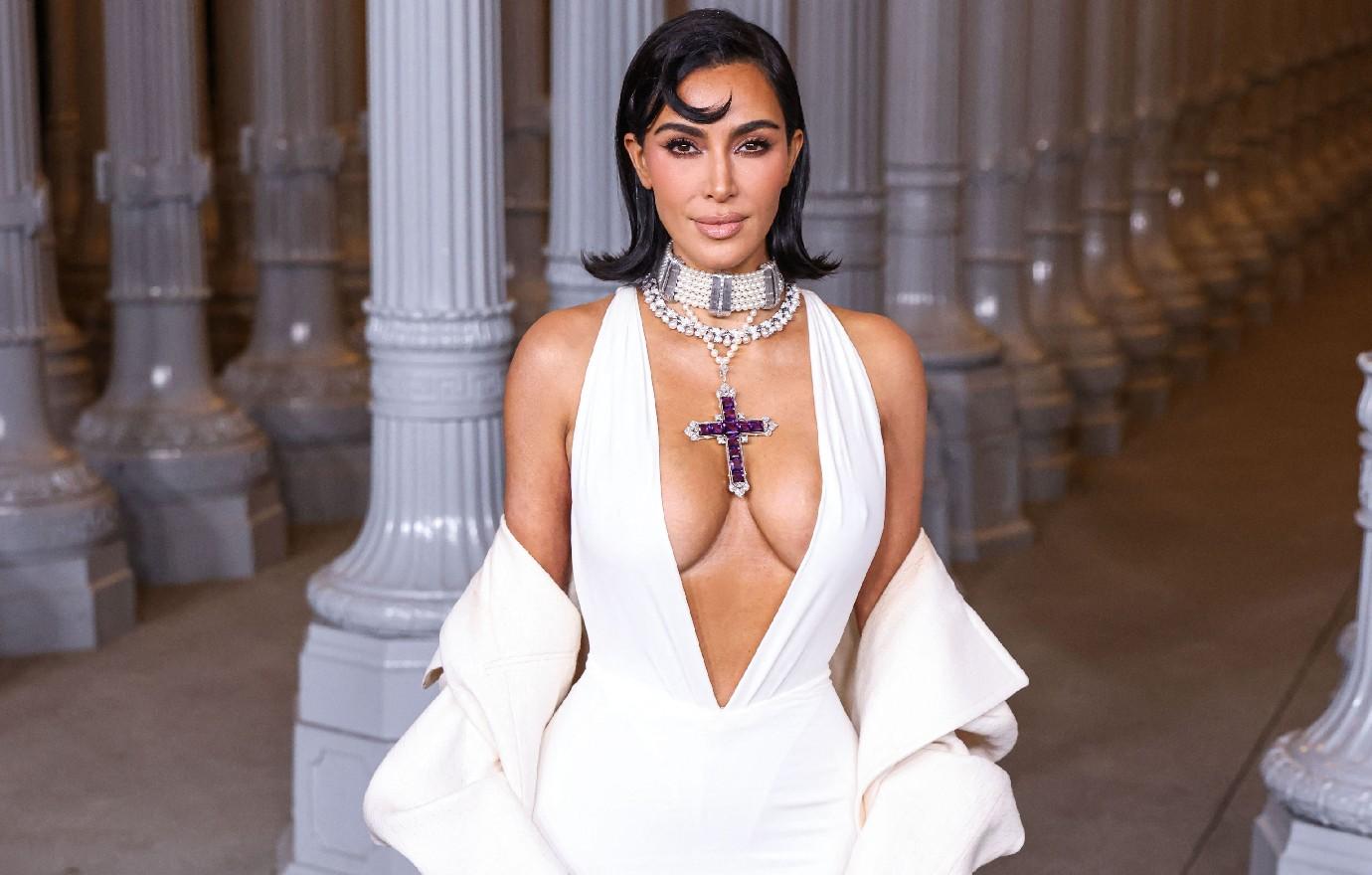 kim kardashian wearing princess diana cross necklace vulgar cleavage