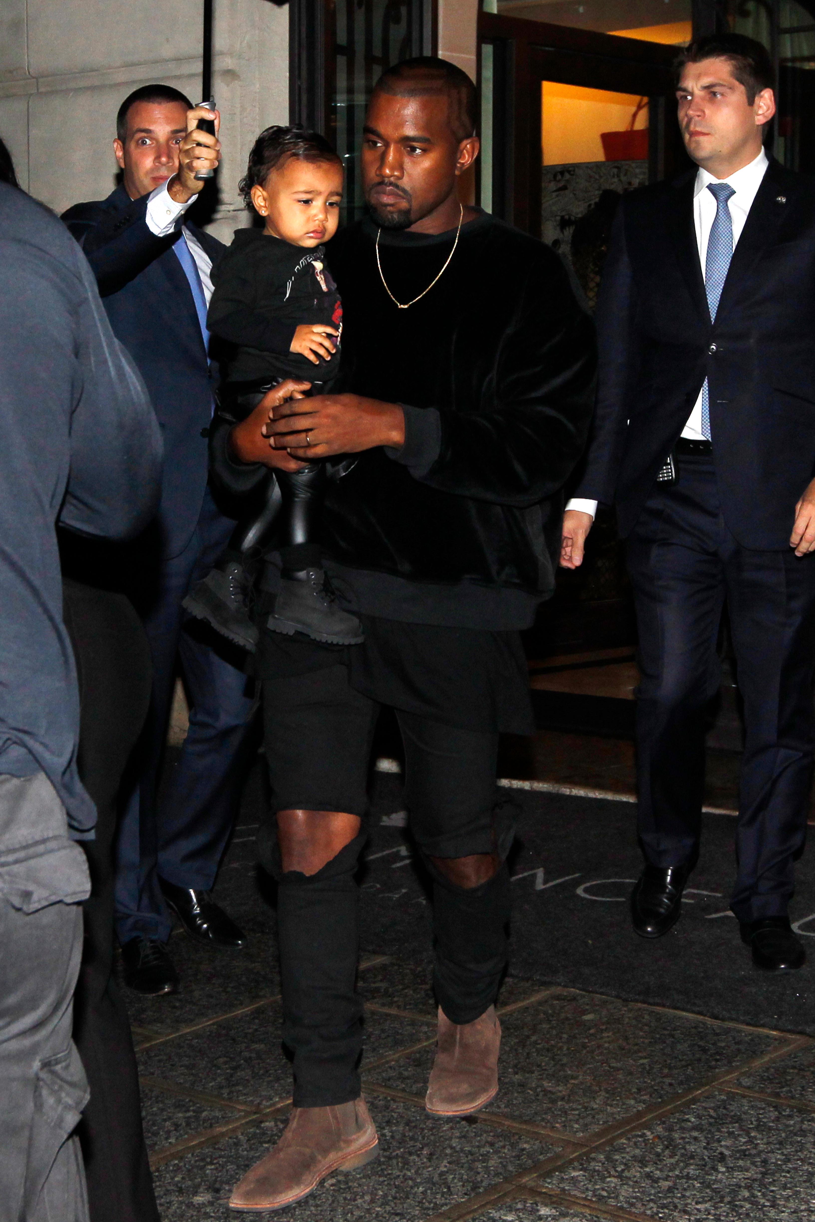 Kanye West, Kim Kardashian and their daughter North West walk to the Balenciaga Womenswear Spring/Summer 2015