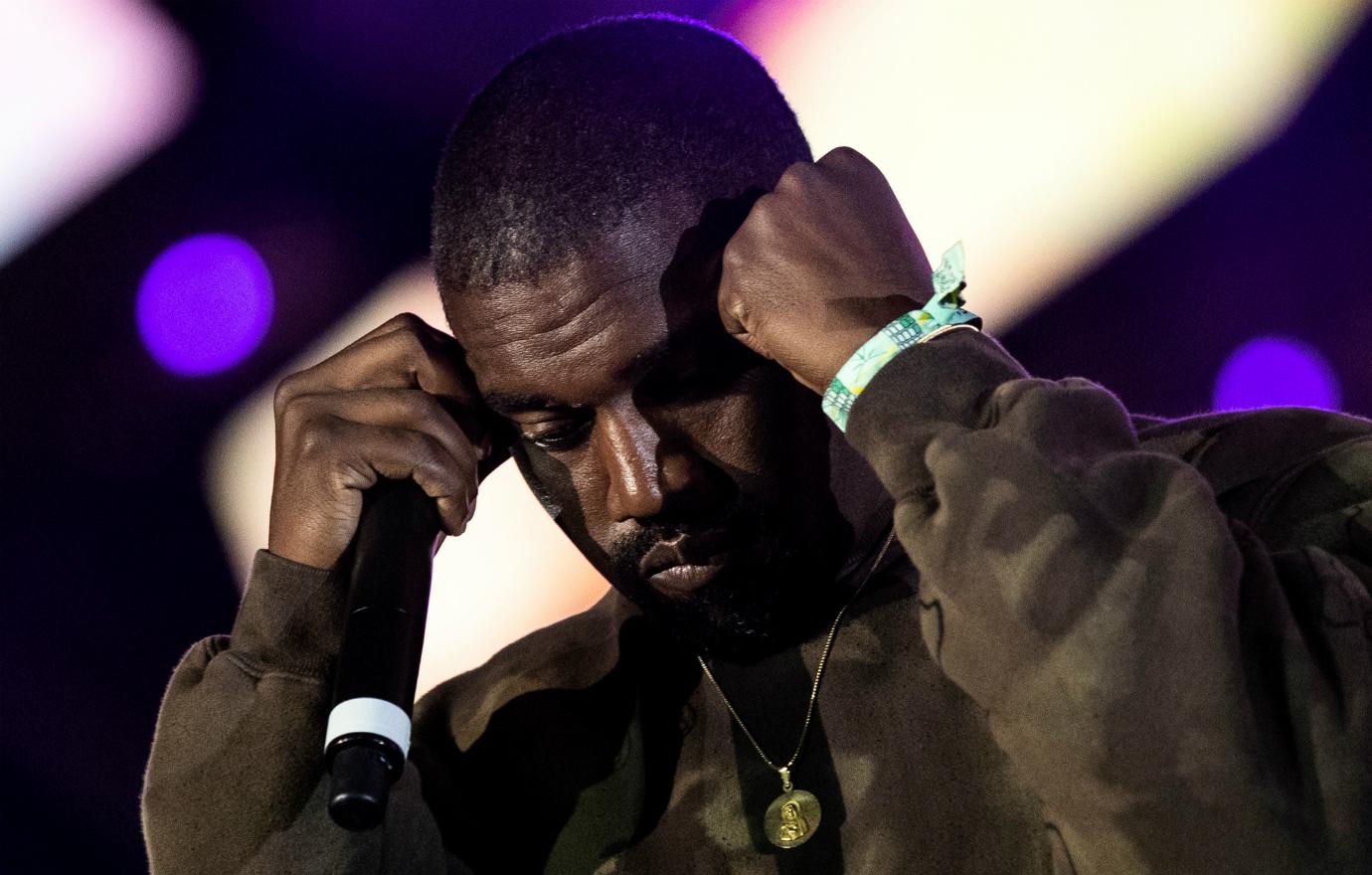 Kanye puts his hands to his head.