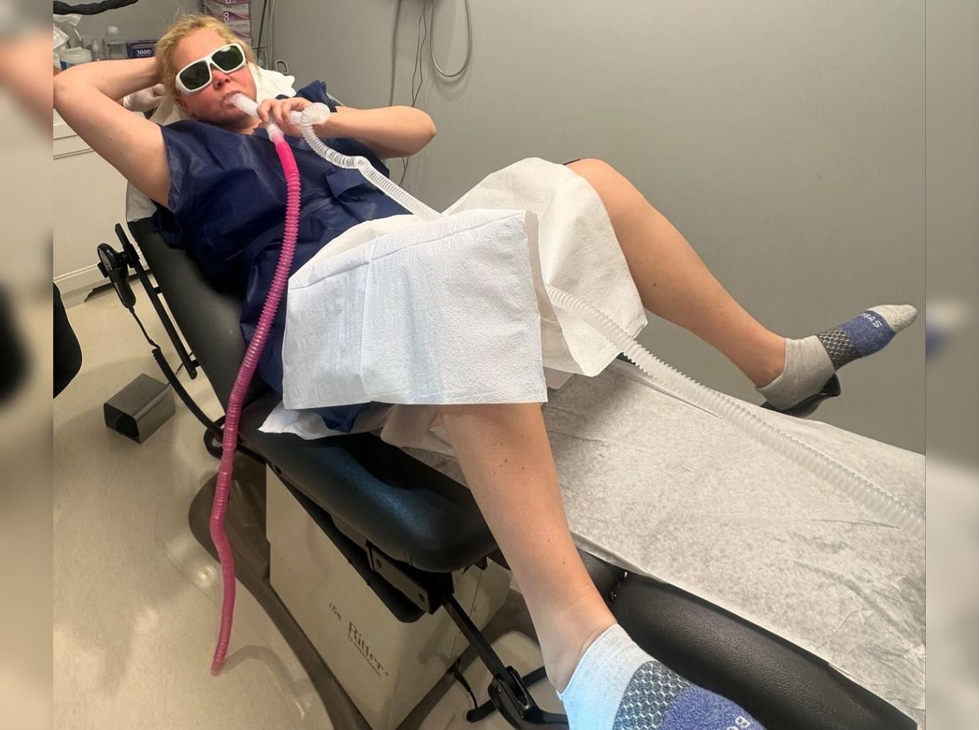 amy schumer poses lying down gynecologist stirrups photo