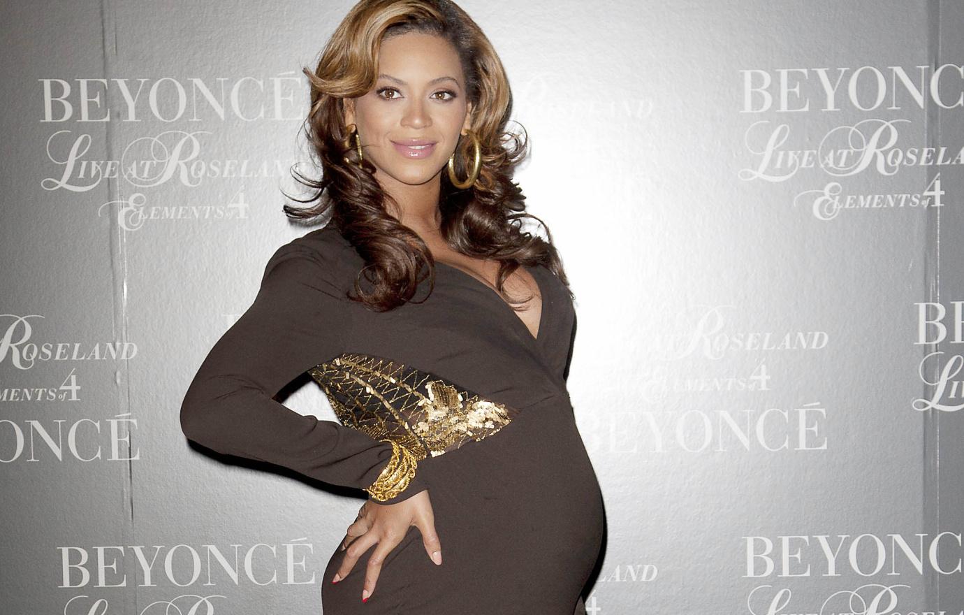 Pregnant Beyonce poses in brown bump-hugging gown