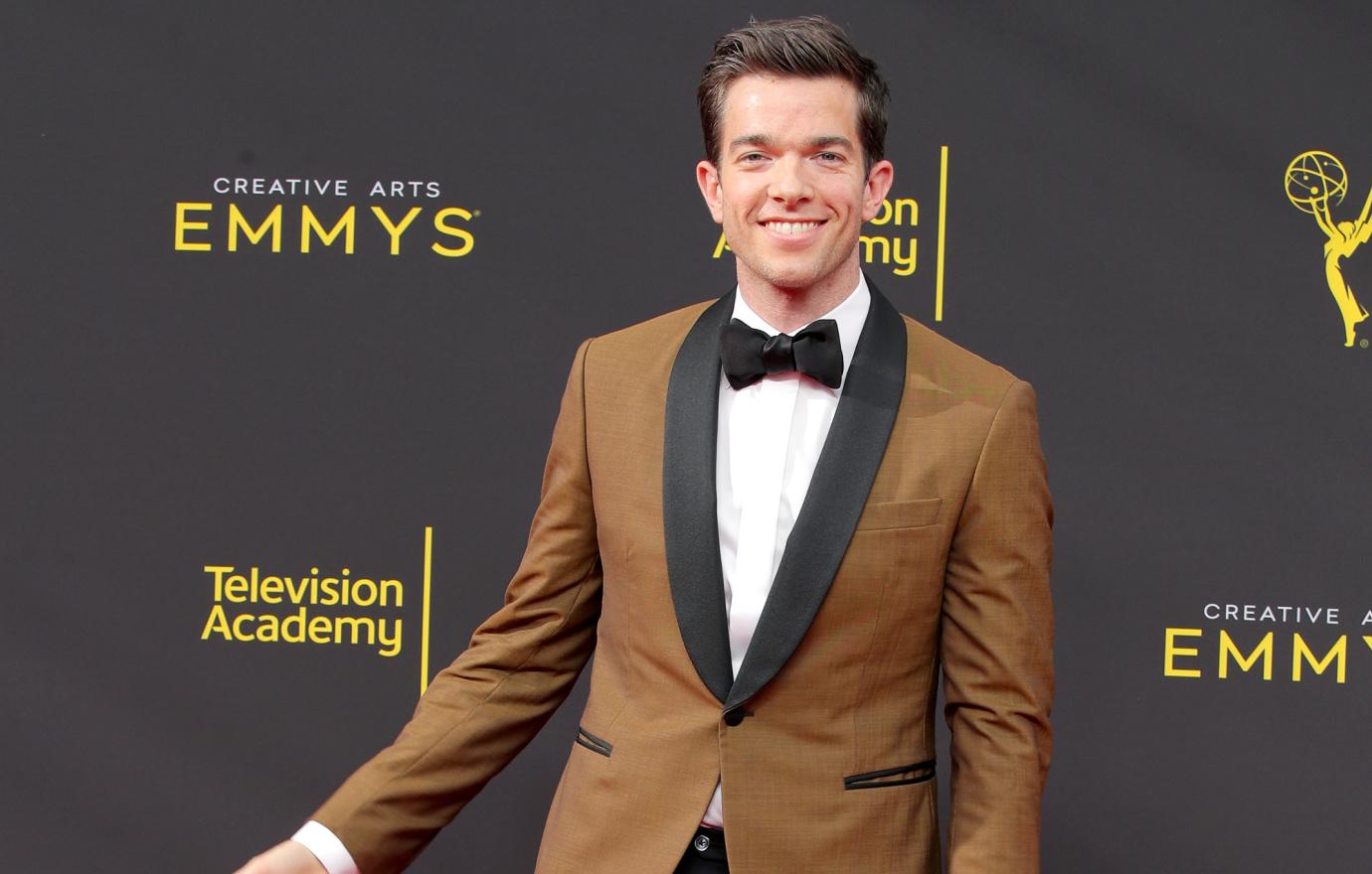 John Mulaney hams it up on the red carpet in a tan suit