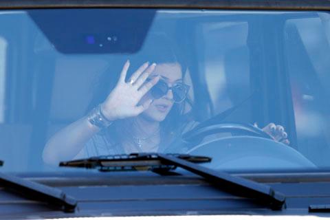 Kylie Jenner gives waiting photographers a wave as she leaves a studio in West Hollywood, Ca