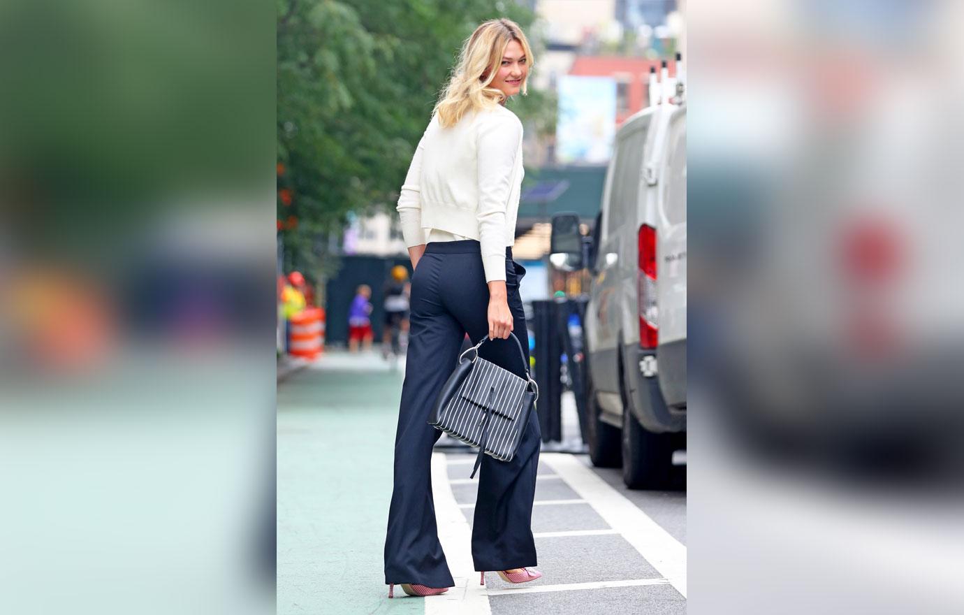 EXCLUSIVE: Karlie Kloss steps out wearing a White plunging neckline top with navy trousers, NYC