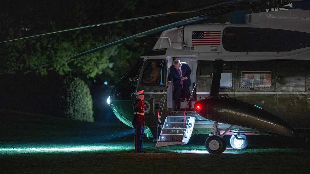 Image of Donald Trump moved cautiously down the steps of Air Force One as he appeared to struggled through windy conditions.