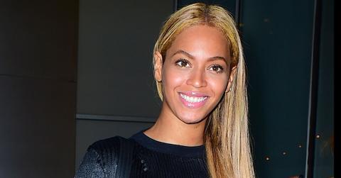 Beyonce smiles looks happy walking out office building