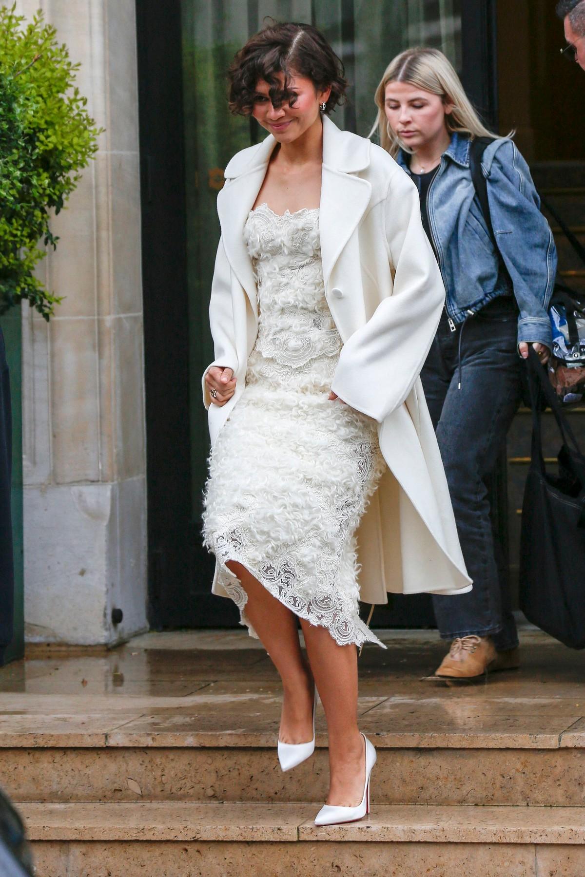 Photo of Zendaya wore a lacy midi dress and long white overcoat for the occasion.
