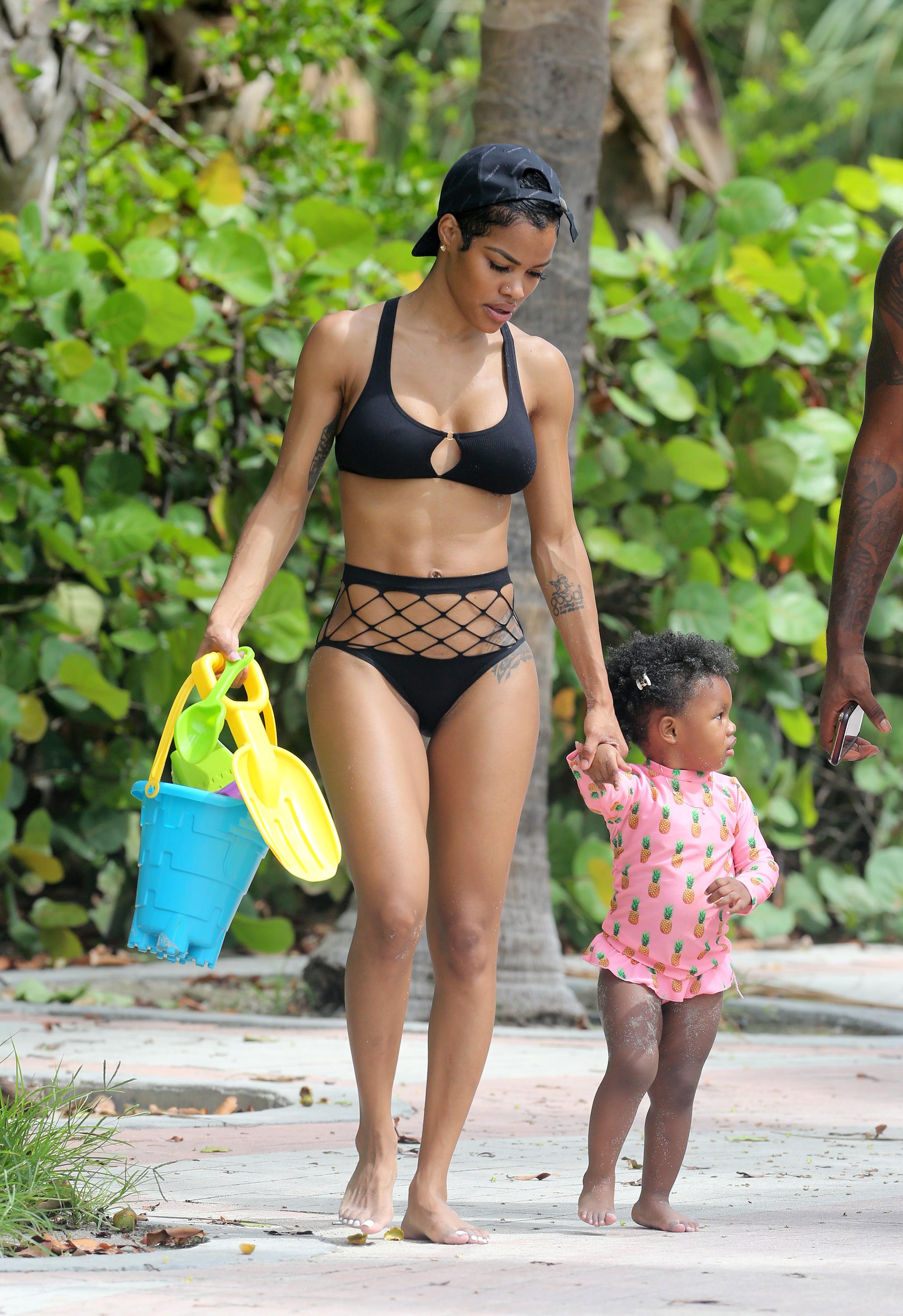 Singer Teyana Taylor shows off her abs in a black bikini on the beach in Miami