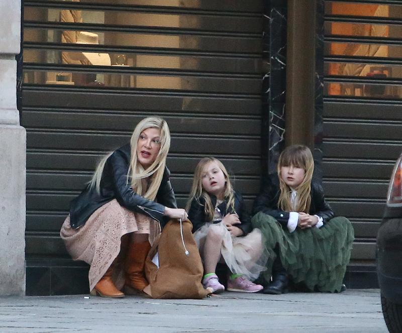 Tori Spelling waiting for taxi in Paris with kids