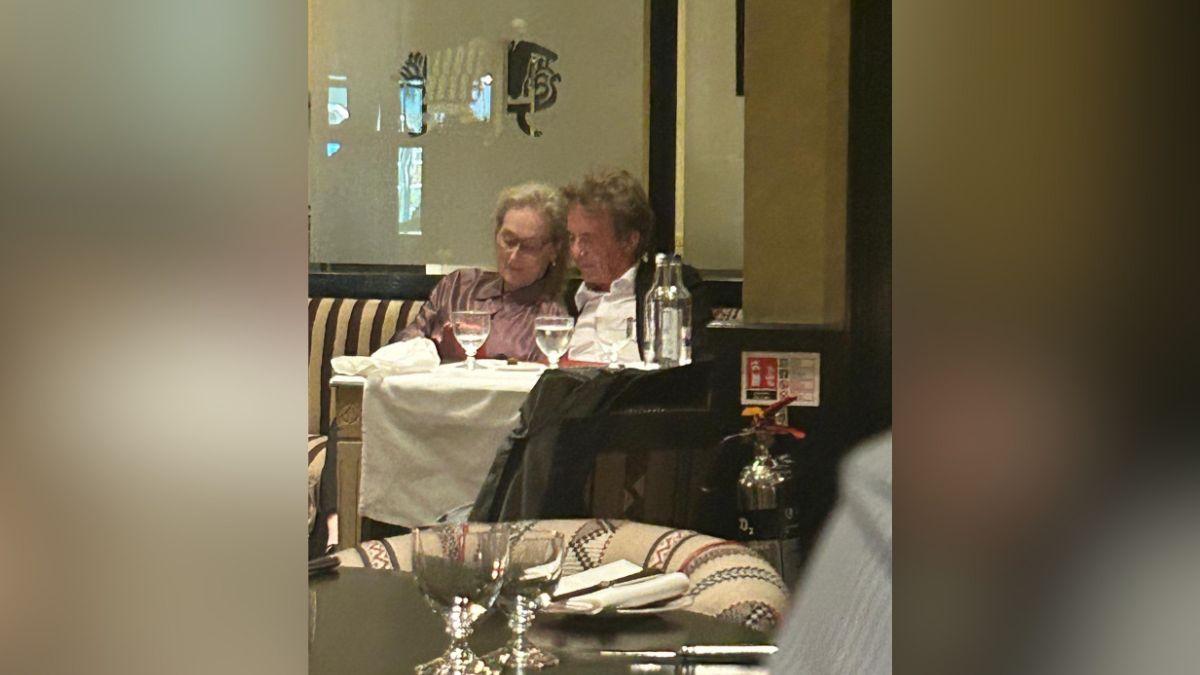 Image of Meryl Streep cuddled up to Martin Short at dinner.